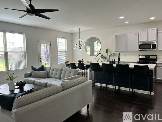 A modern living room with a grey sofa and a black dining table.