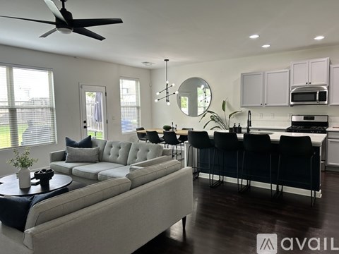 A modern living room with a grey sofa and a black dining table.