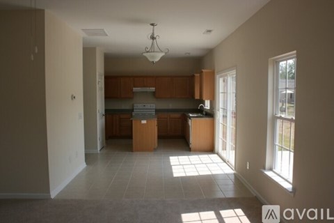 A kitchen with brown cabinets and a black countertop is available for rent.
