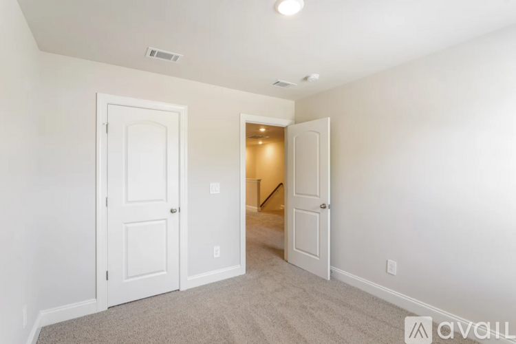 A room with two white doors and a carpeted floor.