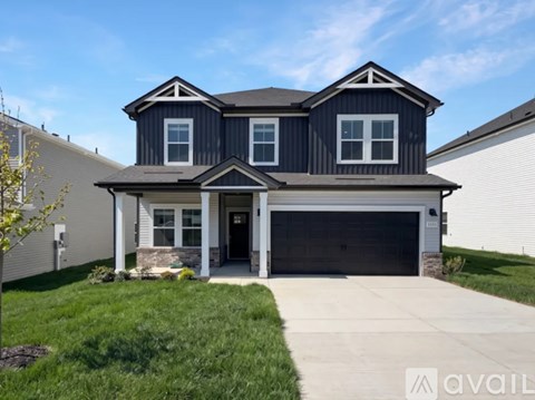 A two-story house with a garage is available for sale.