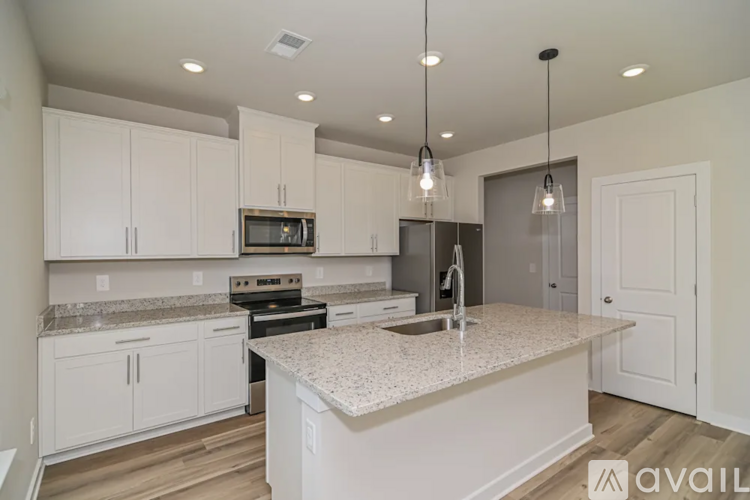 A kitchen with white cabinets and a granite countertop.