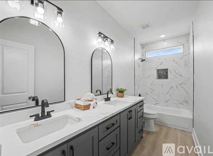 A bathroom with a marble wall and a round mirror.