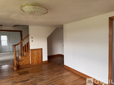 A room with wooden floors and a staircase.