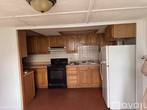 A kitchen with wooden cabinets and a black oven.