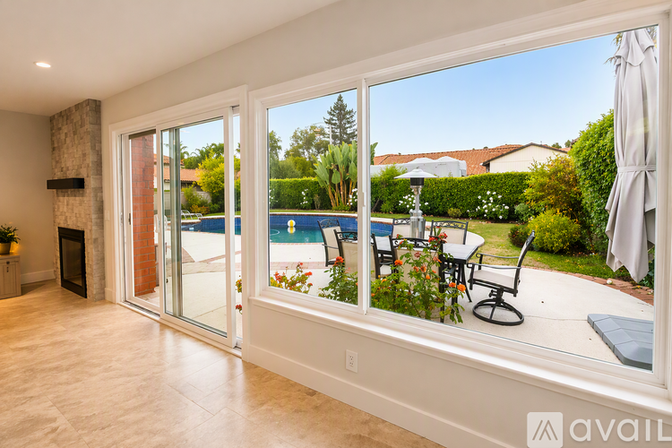 A sunny day outside with a pool and patio furniture.