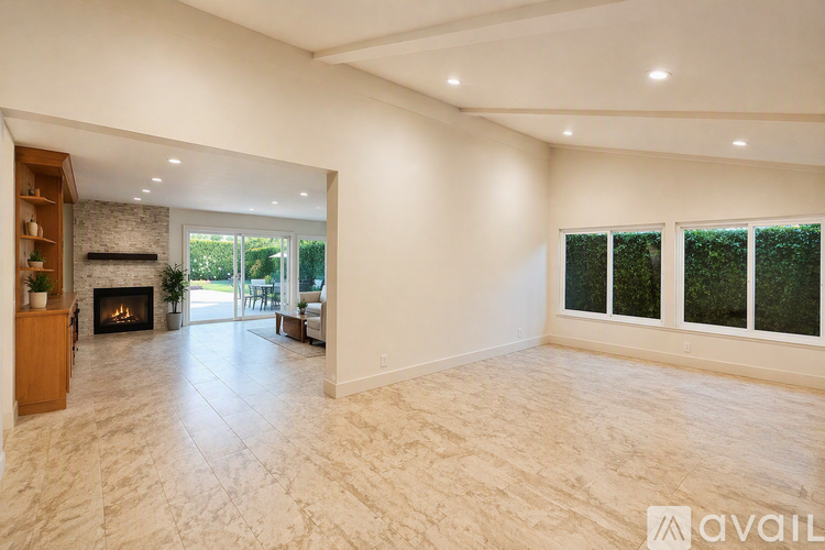 A spacious living room with a fireplace and a marble floor.