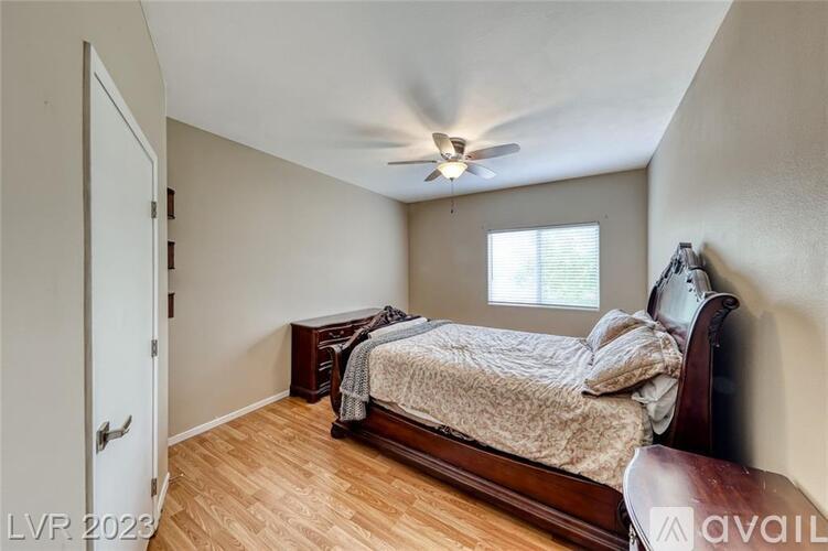 A bedroom with a bed, dresser, and window.