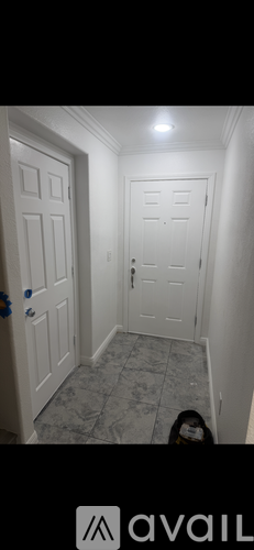 A hallway with a tiled floor and two doors.