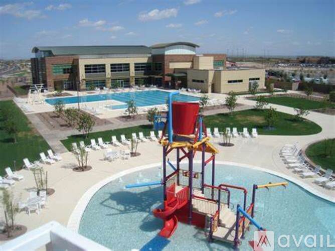 A pool with a slide and a building in the background.