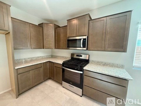 A kitchen with brown cabinets and stainless steel appliances.