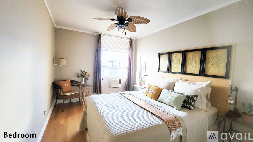 A bedroom with a large bed and a ceiling fan.