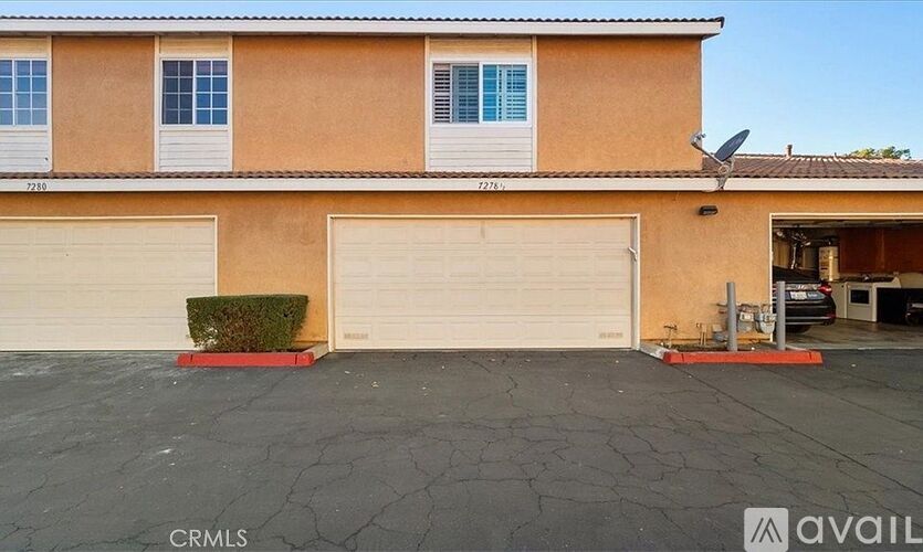 A two-story house with a garage and a satellite dish on the roof.