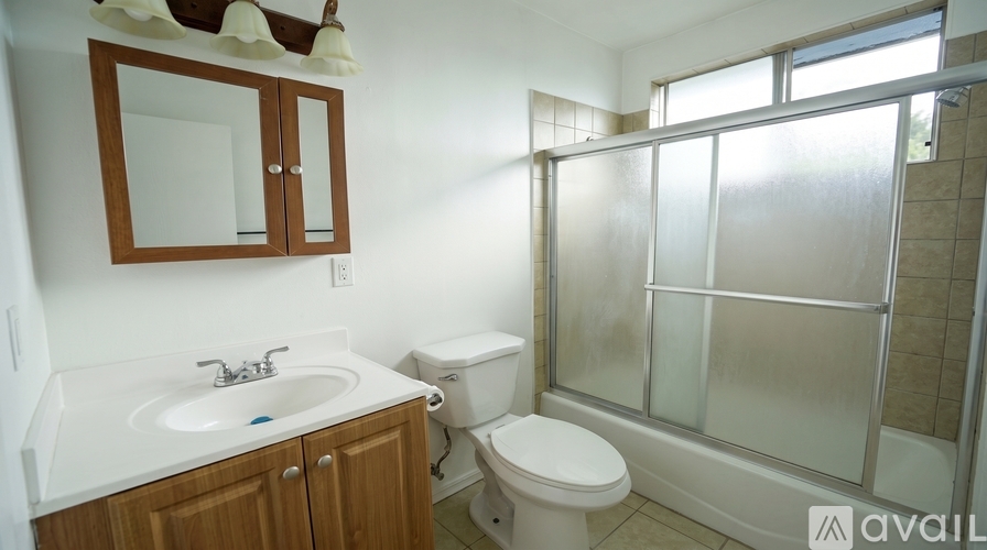 A bathroom with a toilet, sink, and shower.