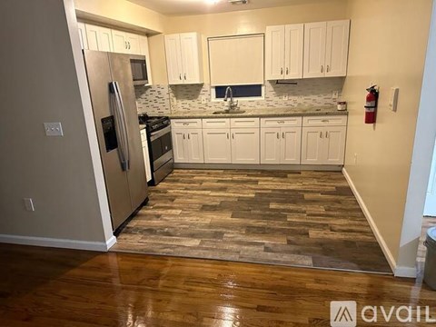 A kitchen with a refrigerator, oven, and sink.