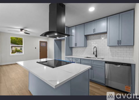 A modern kitchen with a large island and stainless steel appliances.