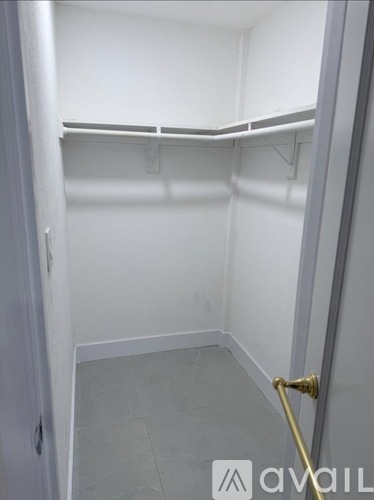 A white closet with a gold hanger.
