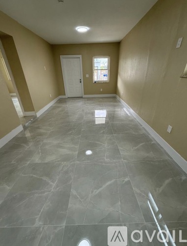 A room with a marble floor and a door.
