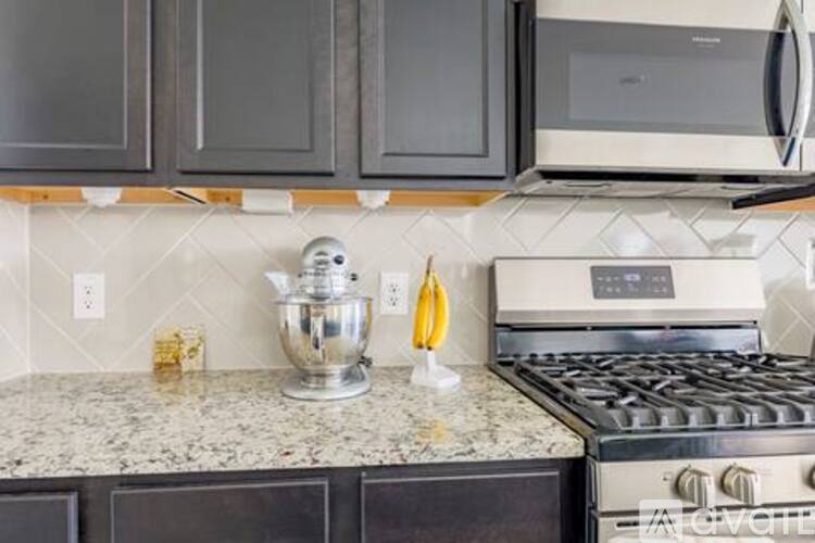 A kitchen with a stove, microwave, and oven.