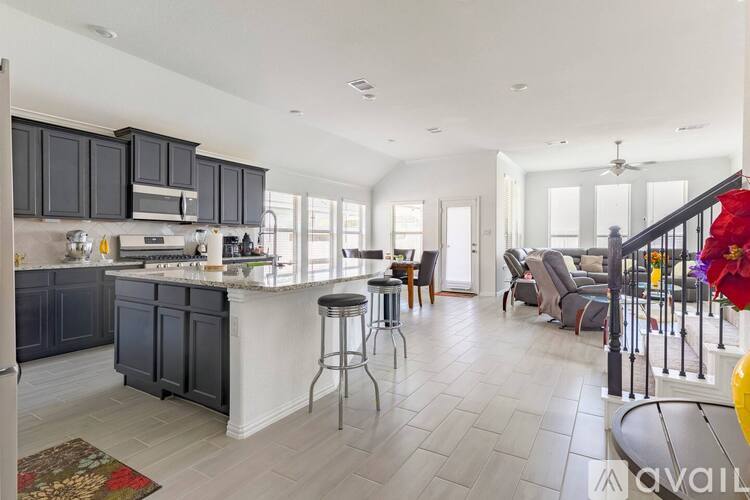 A spacious kitchen with dark cabinets and a white island.