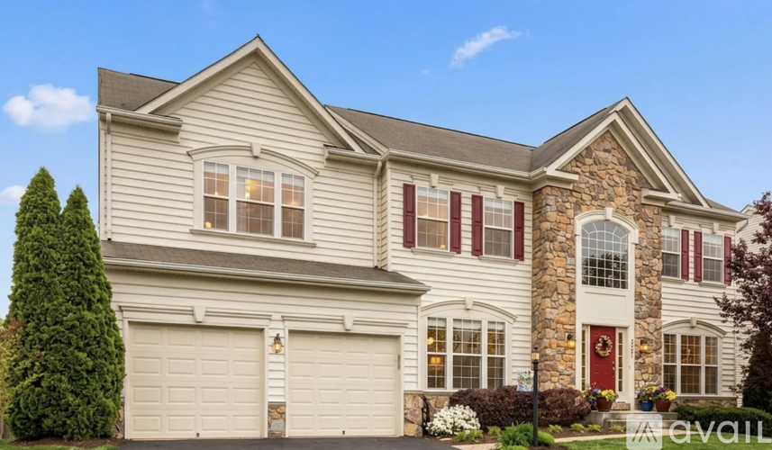 A two-story house with a red door and a garage.