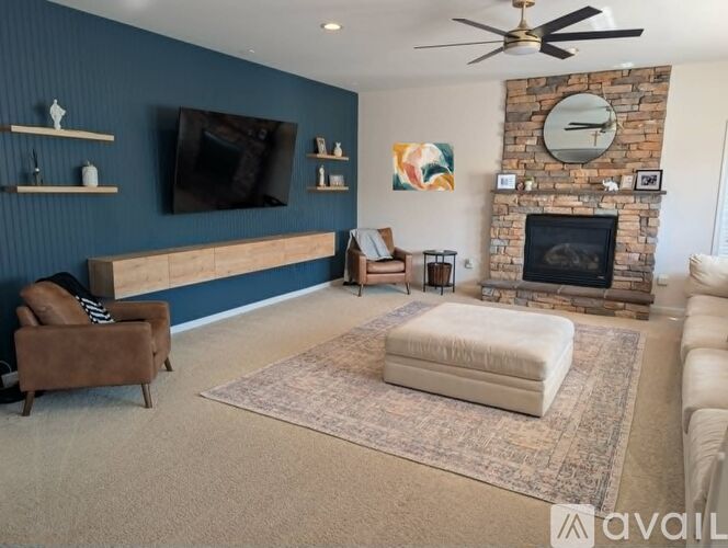 A living room with a fireplace and a flat screen TV mounted on the wall.