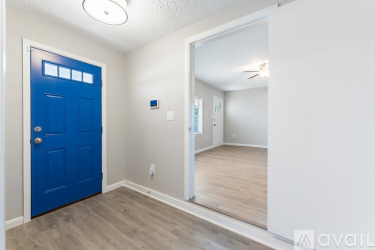 A room with a blue door and a white wall.