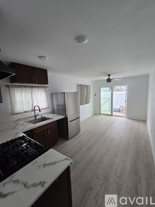 A kitchen with a marble countertop and a fan on the ceiling.