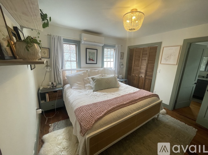 A bedroom with a large bed and a window with curtains.