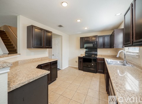 A kitchen with brown cabinets and a granite countertop.