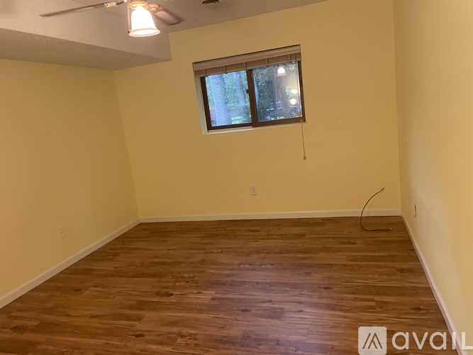 A room with wooden flooring and a window.