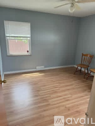 A room with a wooden floor and a ceiling fan.