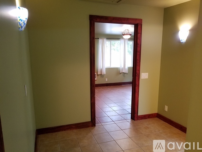 A room with a doorway leading to another room with a window.