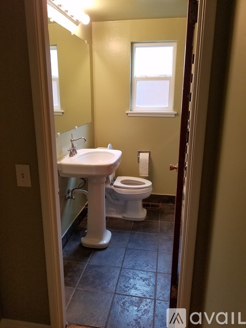 A bathroom with a sink, toilet and mirror.