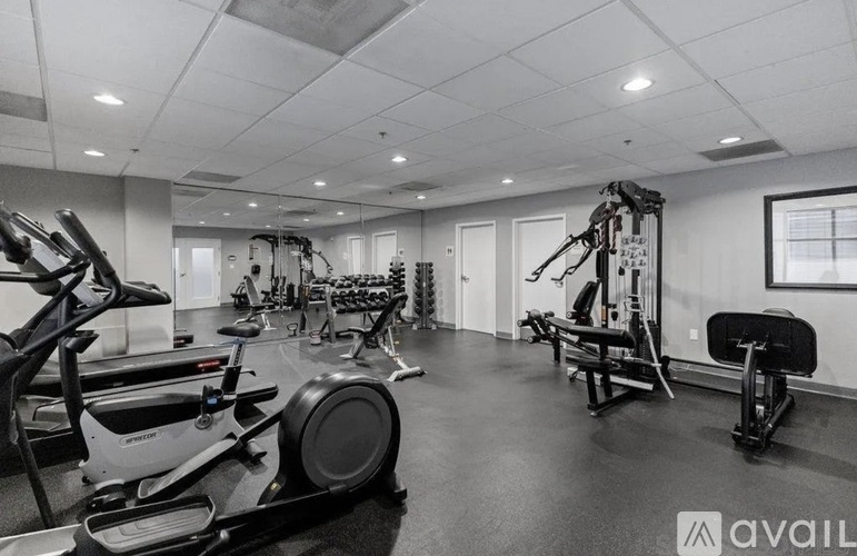 A gym with a variety of exercise equipment including treadmills, stationary bikes, and weight machines.
