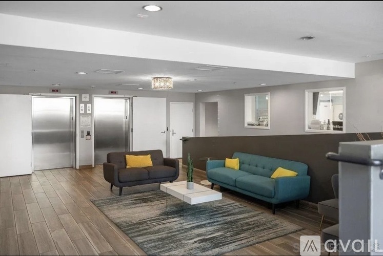 A living room with a grey couch, a black couch, and a white coffee table.