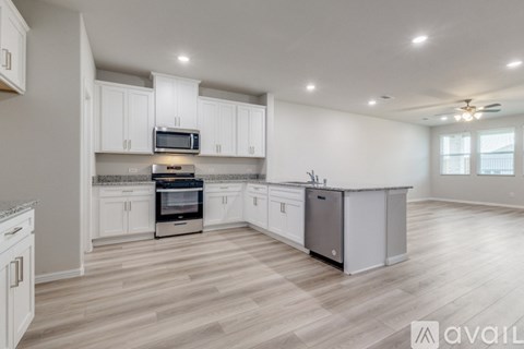 A kitchen with white cabinets and a wooden floor.