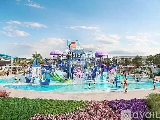 A colorful water park with a large pool and a water slide.