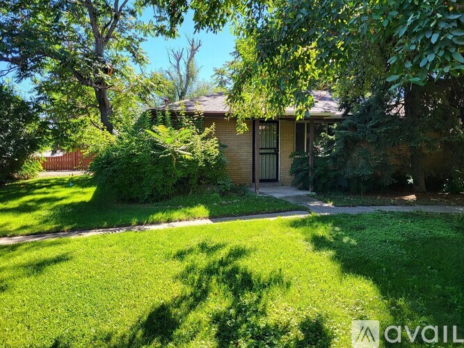 A house with a lawn and trees in front of it.