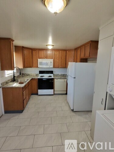 A kitchen with wooden cabinets and a white fridge.