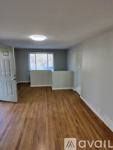 A room with wooden flooring and a white door.