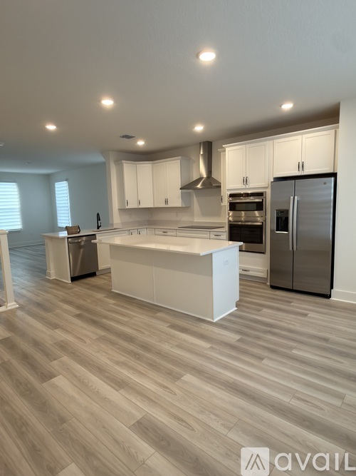 A modern kitchen with a large island and stainless steel appliances.