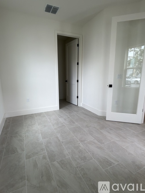 A room with a tiled floor and a white door.