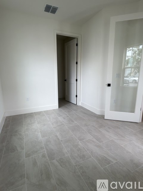 A room with a tiled floor and a white door.