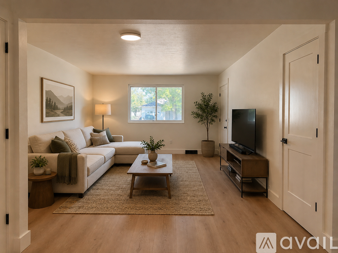 A living room with a couch, a coffee table, and a television.
