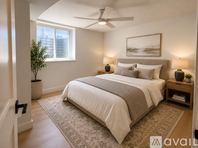 A bedroom with a large bed and a ceiling fan.
