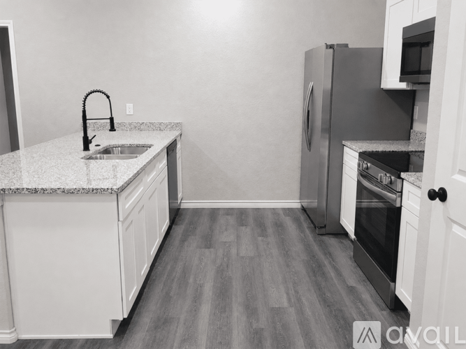 A kitchen with a sink, refrigerator, and oven.