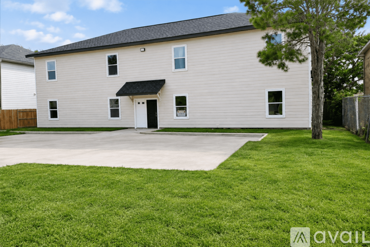 A house with a white exterior and a black roof is available for sale.