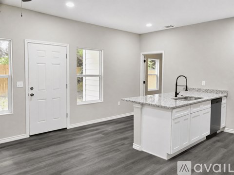 A kitchen with white cabinets and a granite countertop.