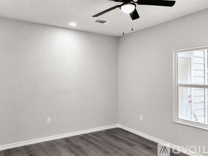 A room with a ceiling fan and a window.